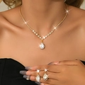 Detailed close-up of a pear-shaped zircon jewelry set on skin with glowing light effects - 2-Piece Set / Gold White