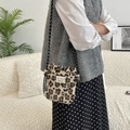 Dettaglio della borsa in peluche leopardata con tracolla intrecciata su modella - Leopardo Crema