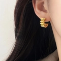 Vintage gold hoop earrings with spiral layered stripes worn on a female ear - 3D Spiral Texture Hoop