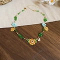 Detail der Sonnenblumen-Halskette mit grünen Perlen und Goldkette auf Holzhintergrund - Sonnenblume Biene Anhänger Schlüsselbeinkette (Gold)