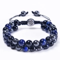 Detail van een dubbellaagse gevlochten armband met blauwe tijgeroog en obsidiaan kralen - Donkerblauw Tijgeroog & Hematiet & Obsidiaan