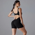 Detail of black V-waist yoga bodysuit showing the back cutout and scrunch butt lifting effect - S / Black
