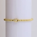 18k gold beaded bracelet featuring a cubic pendant with a crystal-encrusted letter F - Letter F