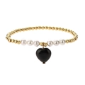 Detailed macro view of beaded bracelet with gold accents, white pearls and a black heart charm - Black Agate