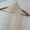 Elegant cream lace scarf with intricate floral embroidery hanging on a wooden hanger - Lace Shawl (w3004) / Beige