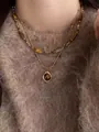 Close-up of double-layer gold tiger eye pendant necklace on a brown knit sweater - Double Layer Beaded Square Pendant (12# Necklace-Gold-Coffee)
