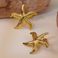 Textured gold starfish stud earrings in stainless steel on a natural stone background - Gold Grainy Starfish Studs