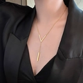 Model draagt een gouden V-vormige ketting met een lange staaf hanger op een zwart jasje - Gouden V-balk Hanger