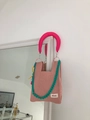 Detail of pink knitted mesh bag featuring a neon handle and blue acrylic chain strap - Lotus Pink + Shoulder Strap Set