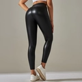 Detail view of high waisted black PU leather leggings with slim fit and glossy finish - Black