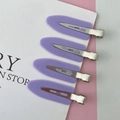 Detail of four purple matte seamless hair clips with silver metal base on decorative card - Purple