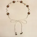 Detail of bohemian woven belt with wooden beads, floral accents and tassel fringe - 19468 Beige