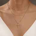 Three-layer gold layered necklace with a cross pendant shown on model's neck - Gold Triple Layer Cross Combination Necklace
