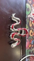 Silver snake-shaped hair claw clip with red enamel accents on dark wooden surface - Silver Snake (Red Enamel)