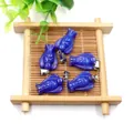 Lapis lazuli angel-shaped pendants with silver bails set on a bamboo display tray - Dyed Lapis Lazuli