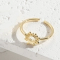 Adjustable gold sun ring with a radiant openwork design on a white stone background - Sun Style