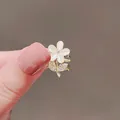 Elegant gold flower ring with cat eye stone petals and zircon accents on a model hand - Cat Eye Flower Clip