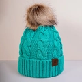Close-up of lake blue cable knit hat featuring a large faux fur pompom and leather logo - One Size / Lake Blue