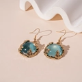 Close-up of vintage gold leaf earrings with round blue translucent resin stones - Blue Resin Ear Hooks