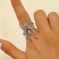 Détail macro de bague araignée gothique avec pierres violettes et cristaux sur la main - Blanc K Strass Violet Rose (WG-0484)