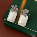 Dettaglio orecchini vintage con pendente di perla e decorazione floreale di strass - Stile Fiore Viola Perla Quadrata Bianca