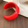 Close-up of bright red acrylic chunky open bangle featuring a unique wrinkled texture - Red - Pleated Open