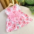 Pink floral pet dress detail with a large bow hanging on a wooden hanger on marble - Pink Petunia