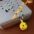 Detail of handmade beaded necklace featuring a 3D yellow smiley face pendant on a velvet box - Yellow Smiling Face Black White Seed Bead Necklace