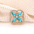 Macro detail of gold four-leaf clover brooch with blue marquise crystals and clear rhinestones - Lake Blue