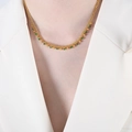 Collier pompon en acier titane doré avec perles vertes et dorées porté par un modèle - Vert