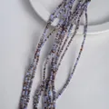 Strands of blue, purple, and brown natural shell beads on a minimalist white ceramic plate - 2mm / Blue Series