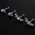Primer plano de piercings labret de titanio 16G con opalos blancos y azules y cristales - Estilo 1 / Plateado