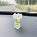 Car dashboard ornament featuring a small glass vase with white flowers and good luck label - White Gypsophila