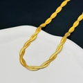 Detail view of multi-strand twisted gold flat snake chain necklace on ceramic plate - Double Layer Necklace / Gold