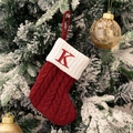 Calza di Natale in maglia rossa con lettera K ricamata appesa a un albero innevato - Calza con Lettera Rossa-K