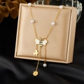Détail d'un collier pendentif abeille dorée avec perles blanches et breloques fleurs - Collier Abeille à Pompons (N3524)