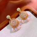 Dettaglio di orecchini boho dorati con nappe e perline colorate su vassoio di lino - Pendenti Tondi Rosa con Perno in Argento
