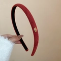 Dettaglio del cerchietto in velluto rosso vino con piastrina d'oro Love e fodera antiscivolo - Rosso