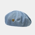 Detail van lichtblauwe denim baret met gouden C-badge en nette stiksels - Lichtblauw / M (56-58cm)