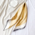Détail d'un foulard en soie à motif pied-de-poule jaune et blanc sur plateau blanc - 70x70cm / Jaune