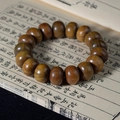 Gros plan d'un bracelet en bois de santal sur papier vintage montrant le grain naturel - Bois de santal vert / 19mm x 17 Pcs