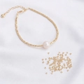 Vista macro de cuentas triangulares de oro de 14K y pulsera artesanal con perla - 2mm Triángulo Dorado [50 Piezas] / Dorado