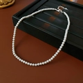 Detalle de collar de perlas blancas con cierre plateado sobre estuche de cuero - Gris-4mm
