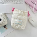 Vista ravvicinata di una borsa trapuntata color crema con cordoncini rosa su una scrivania - Nuvola bianco crema trapuntata
