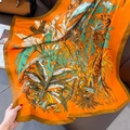 Détail d'un foulard orange vif avec imprimés tropicaux de girafes et de jungle - Orange