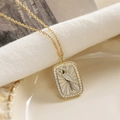 Gold tarot style necklace with heron pendant and zircon inlay on a soft background - Egret/Bird