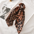 Detailed view of leopard print satin scrunchie with long ribbons on a white tray - Coffee Leopard