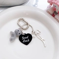 Détail du pendentif chat floqué gris avec nœud argenté et porte-clés cœur Good Luck - Porte-clés Chat Gris Couché