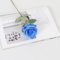 Lifelike blue velvet artificial rose stem with green leaves on a magazine background - Silk Royal Blue