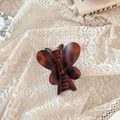 Gros plan d'une pince à cheveux papillon en écaille de tortue sur tissu en dentelle - Fermoir papillon / Env. 8cm / Tortue Mate